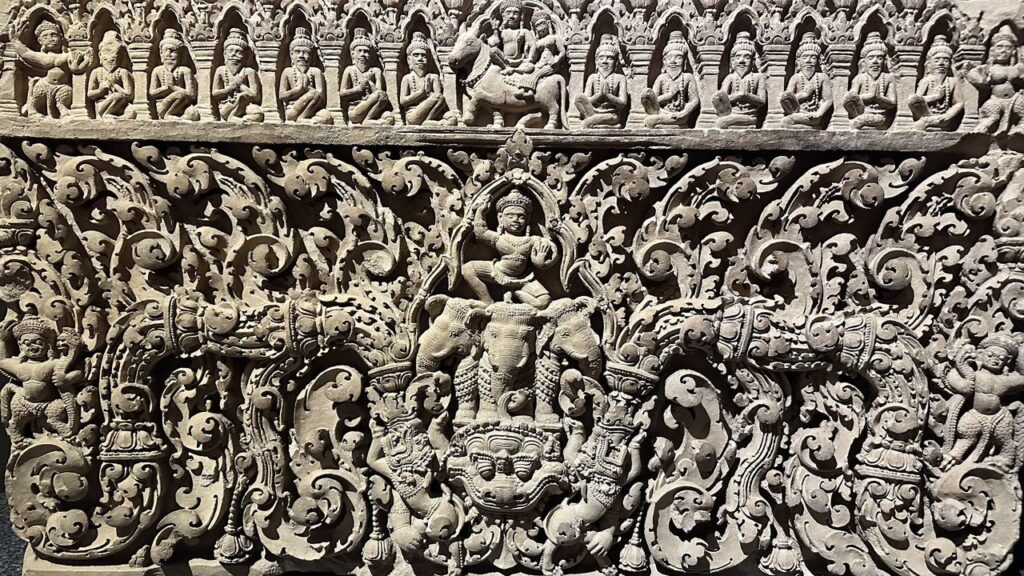 Wunderschönes Steinrelief: In der Mitte reitet eine Gottheit auf einem Elefanten, umgeben von Mustern, Fabelwesen und Figuren.
