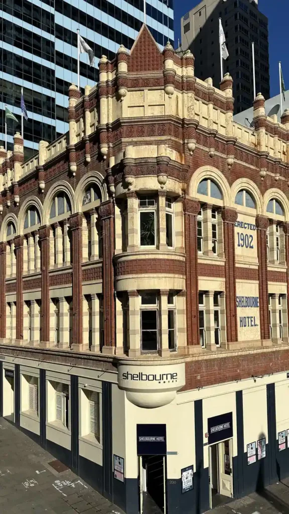 Das charmante Shelbourne Hotel von 1902 mit roter Backsteinfassade leuchtet vor moderner Skyline im Hintergrund.