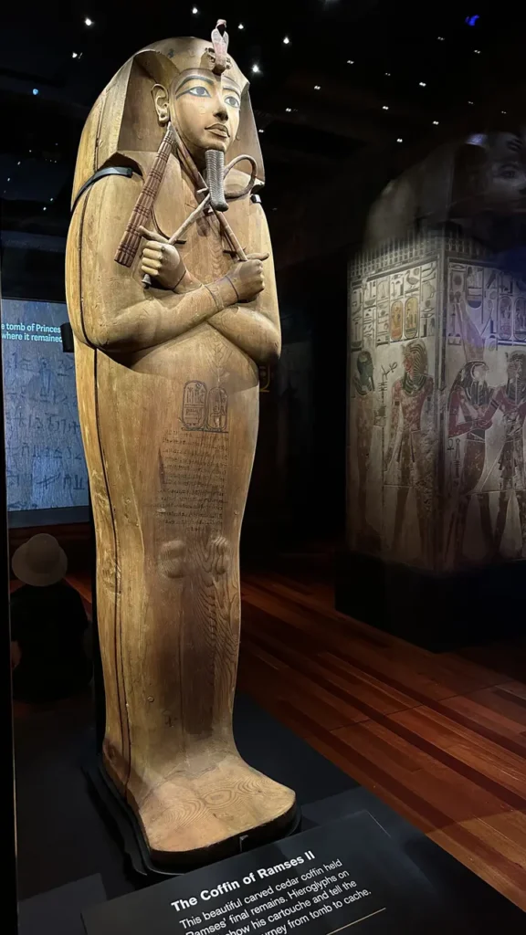 Im Museum steht aufrecht der hölzerne Sarkophag Ramses II. mit kunstvollen Details, umgeben von Hieroglyphenwänden.