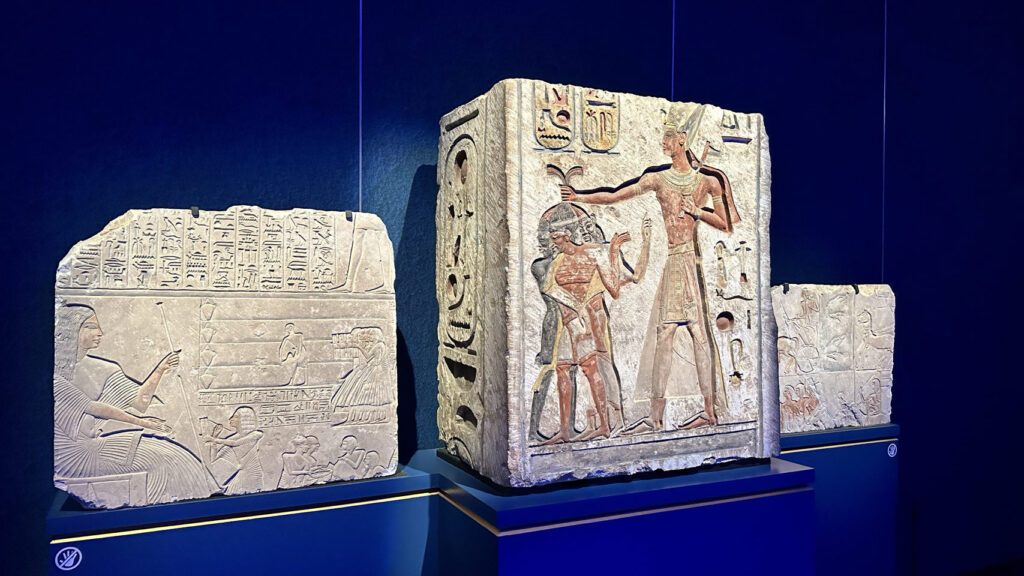 Im Museum bestaunen wir drei altägyptische Steintafeln, zentral ein Gott mit Stab und Ankh, umgeben von Hieroglyphen.